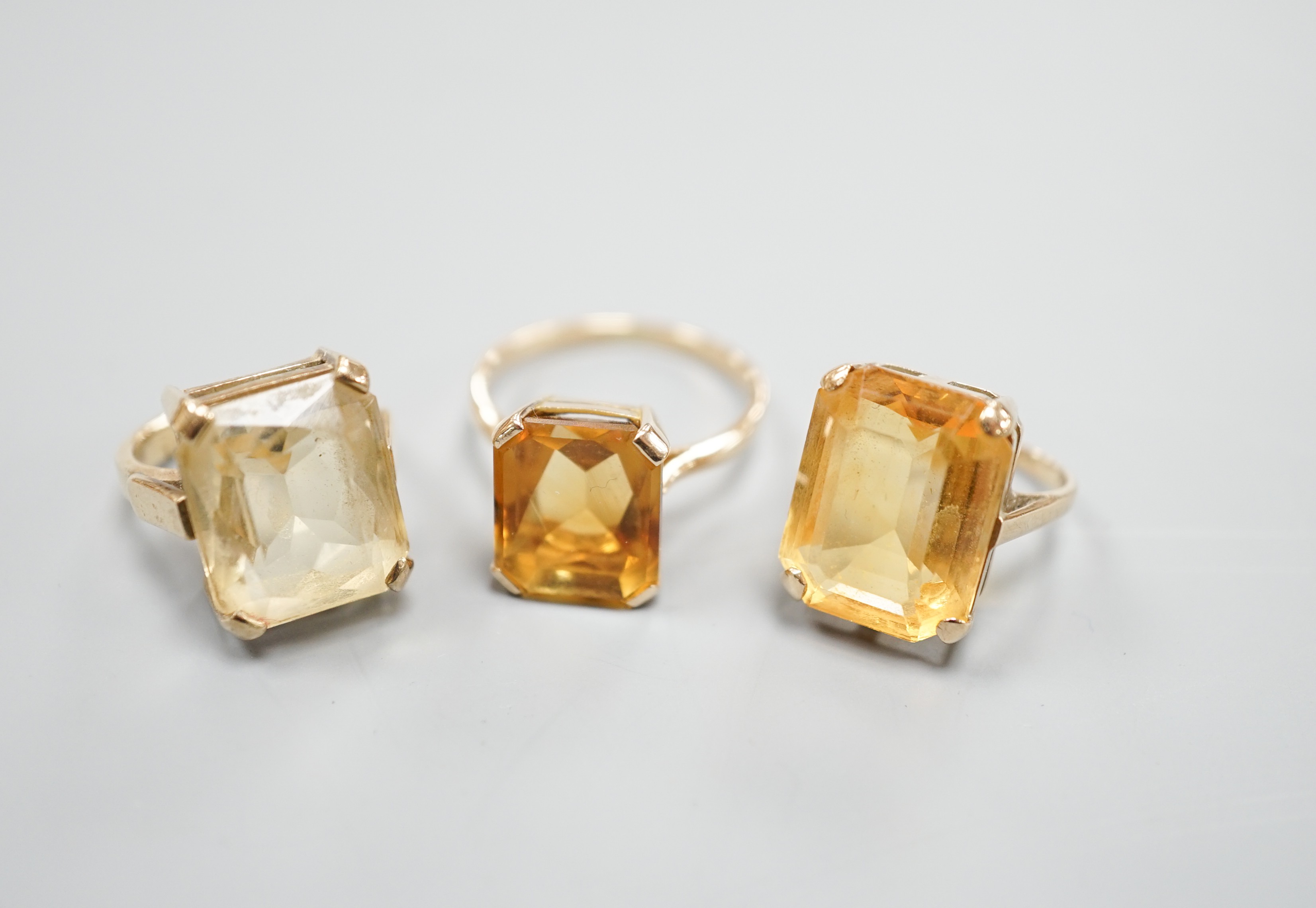 Three yellow metal and citrine set dress rings, one stamped 9ct, gross weight 11.9 grams.